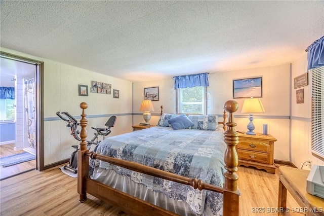 15852 Kindling Rd, Eldridge, MO 65463 - bedroom with light wood-style floors, a textured ceiling, baseboards, and ensuite bath