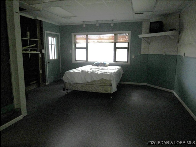 bedroom with track lighting and baseboards
