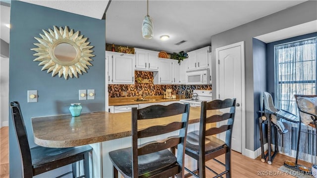 101 Circle Edge Unit 20-3A, Lake Ozark, MO 65049 - kitchen with white appliances, white cabinetry, tasteful backsplash, light wood-style flooring, and a sink