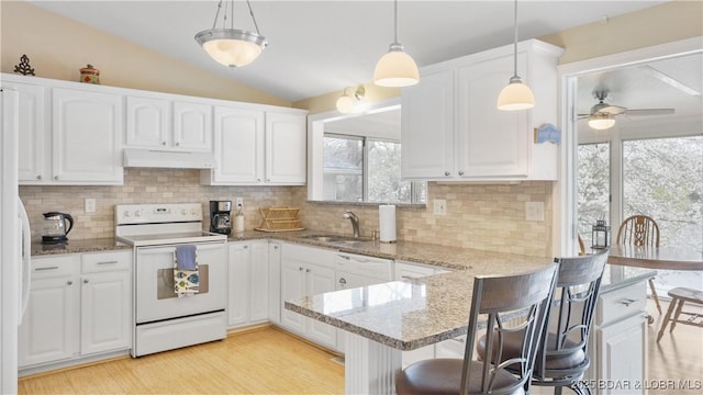 88 Hendrix Haven Dr, Sunrise Beach, MO 65079 - kitchen with white appliances, under cabinet range hood, white cabinetry, a peninsula, and vaulted ceiling