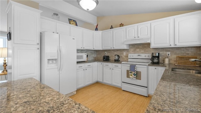 88 Hendrix Haven Dr, Sunrise Beach, MO 65079 - kitchen with white appliances, lofted ceiling, a sink, under cabinet range hood, and decorative backsplash