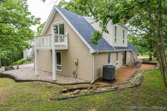 1556 Mockingbird Ln, Osage Beach, MO 65065 - back of house featuring central AC unit, roof with shingles, a balcony, and a patio