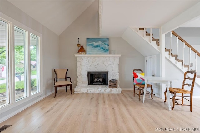 1556 Mockingbird Ln, Osage Beach, MO 65065 - living area featuring wood finished floors, a fireplace, baseboards, lofted ceiling, and stairway