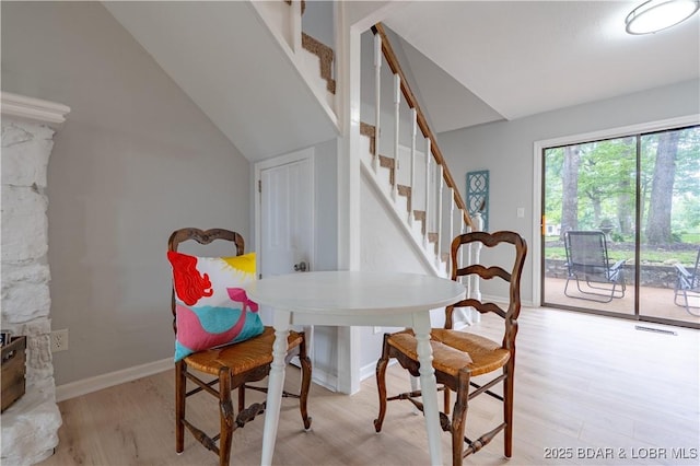 1556 Mockingbird Ln, Osage Beach, MO 65065 - dining room featuring light wood-style floors, stairs, lofted ceiling, and baseboards
