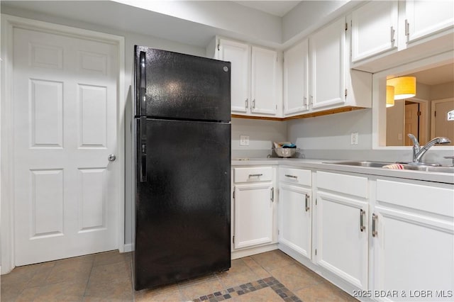 1556 Mockingbird Ln, Osage Beach, MO 65065 - kitchen with freestanding refrigerator, a sink, white cabinets, and light countertops