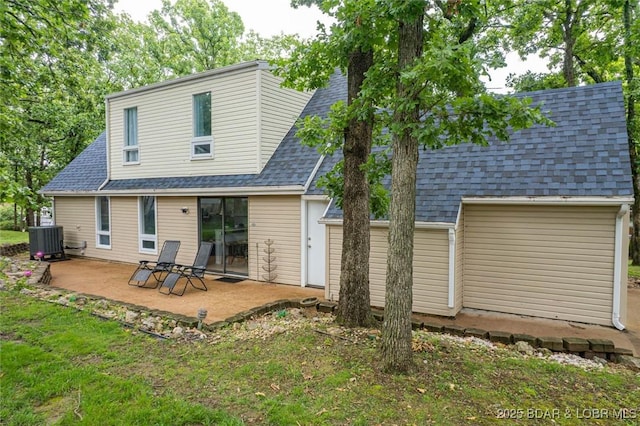 1556 Mockingbird Ln, Osage Beach, MO 65065 - rear view of house featuring a shingled roof, a patio, central air condition unit, and a yard