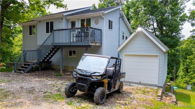 29825 Button Wood Ln, Rocky Mount, MO 65072 - back of house featuring a garage, a wooden deck, stairs, and an outbuilding