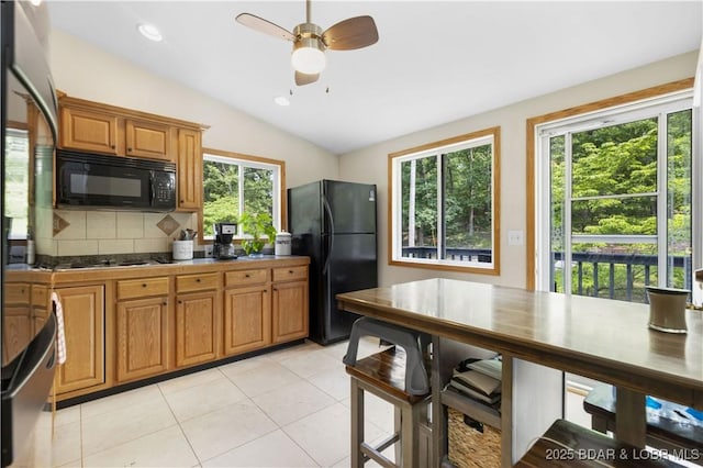 29825 Button Wood Ln, Rocky Mount, MO 65072 - kitchen with black appliances, backsplash, brown cabinets, vaulted ceiling, and a ceiling fan