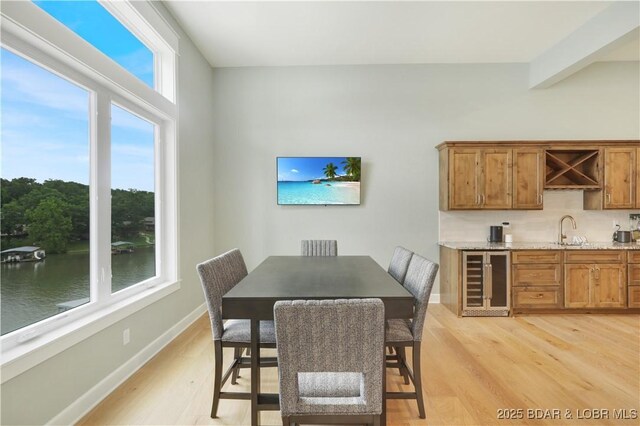 152 Pearl Ln, Climax Springs, MO 65324 - dining space with wine cooler, light wood-style flooring, baseboards, and bar
