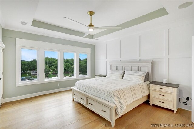 152 Pearl Ln, Climax Springs, MO 65324 - bedroom with a tray ceiling, light wood-style floors, ceiling fan, and baseboards