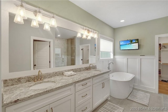 152 Pearl Ln, Climax Springs, MO 65324 - full bath with a stall shower, double vanity, a freestanding tub, a wainscoted wall, and tile patterned flooring