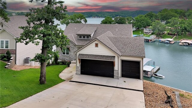 152 Pearl Ln, Climax Springs, MO 65324 - view of front of home with driveway, stone siding, a water view, and roof with shingles