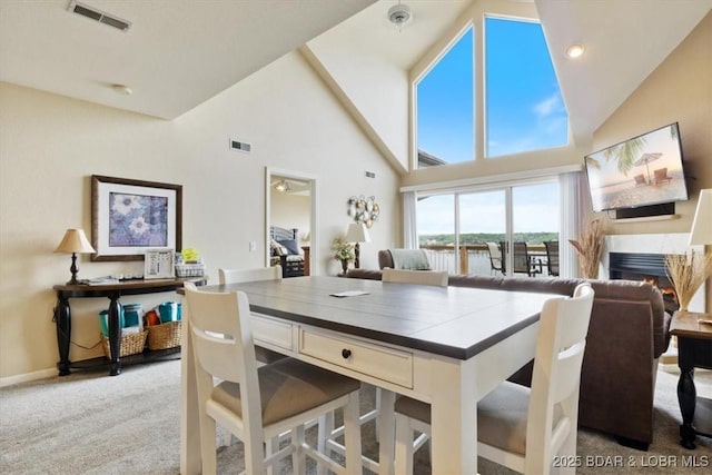 1481 Ledges Dr Unit 1047, Osage Beach, MO 65065 - dining space with carpet floors, high vaulted ceiling, and a lit fireplace
