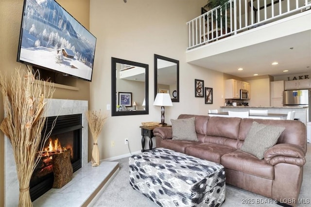 1481 Ledges Dr Unit 1047, Osage Beach, MO 65065 - living area with light colored carpet, a premium fireplace, a high ceiling, and recessed lighting