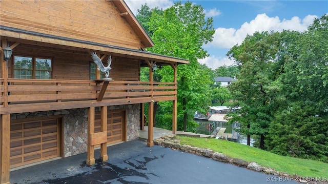 1624 Kays Point Rd, Four Seasons, MO 65049 - view of side of home with stone siding, a garage, asphalt driveway, and a deck
