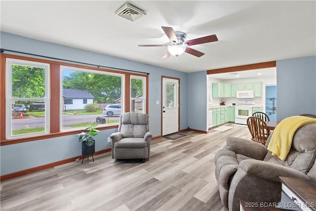 320 N Chestnut St, Eldon, MO 65026 - living area featuring healthy amount of natural light, baseboards, light wood finished floors, and ceiling fan