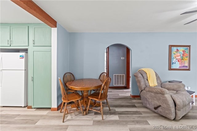 320 N Chestnut St, Eldon, MO 65026 - dining space with arched walkways, light wood finished floors, baseboards, and a ceiling fan