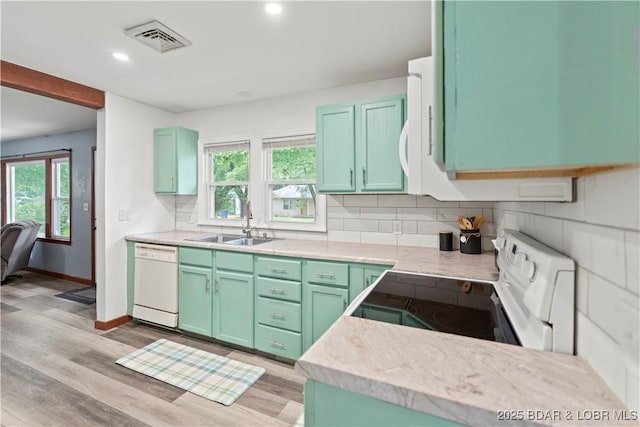 320 N Chestnut St, Eldon, MO 65026 - kitchen with white appliances, a sink, backsplash, light wood-style floors, and recessed lighting