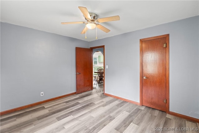 320 N Chestnut St, Eldon, MO 65026 - spare room with light wood-style flooring, ceiling fan, baseboards, and arched walkways