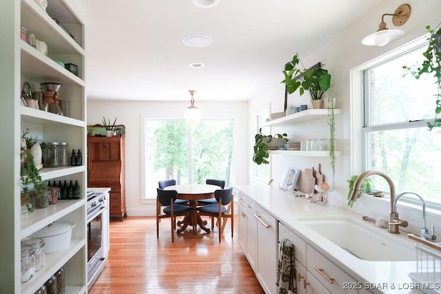 248 Midway Rd, Eldon, MO 65026 - kitchen featuring open shelves, a sink, light wood finished floors, stainless steel range, and white cabinets