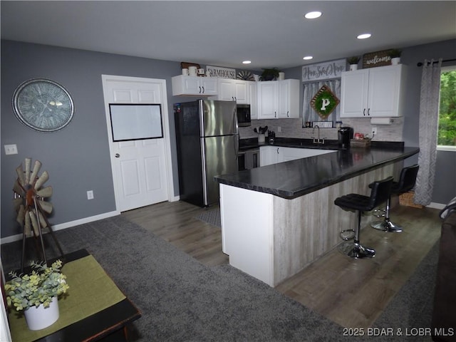 31762 Pecan Dr, Rocky Mount, MO 65072 - kitchen with stainless steel appliances, dark countertops, white cabinetry, dark wood-style floors, and recessed lighting