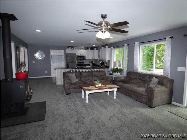 31762 Pecan Dr, Rocky Mount, MO 65072 - living area with a wood stove, dark colored carpet, a ceiling fan, and recessed lighting