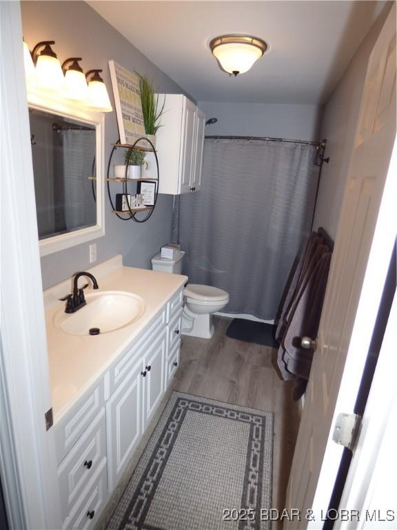31762 Pecan Dr, Rocky Mount, MO 65072 - full bathroom featuring vanity, wood finished floors, and curtained shower