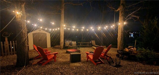 31762 Pecan Dr, Rocky Mount, MO 65072 - patio at night with a fire pit and a storage shed