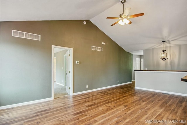 1380 Bluff Dr, Osage Beach, MO 65065 - unfurnished living room with high vaulted ceiling, a ceiling fan, wood finished floors, and baseboards