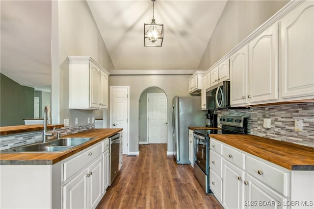 1380 Bluff Dr, Osage Beach, MO 65065 - kitchen featuring butcher block countertops, stainless steel appliances, vaulted ceiling, a sink, and decorative backsplash