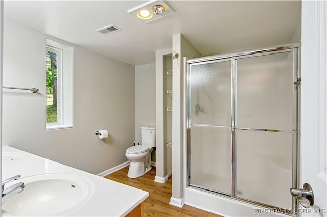 1380 Bluff Dr, Osage Beach, MO 65065 - full bathroom with double vanity, a stall shower, wood finished floors, and toilet