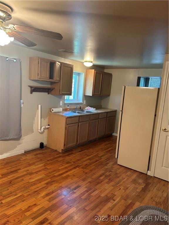 32585 N Ivy Bend Rd, Stover, MO 65078 - kitchen featuring freestanding refrigerator, wood finished floors, a sink, ceiling fan, and light countertops