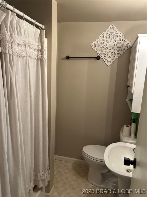 32585 N Ivy Bend Rd, Stover, MO 65078 - full bathroom with toilet, a sink, baseboards, and a shower with curtain