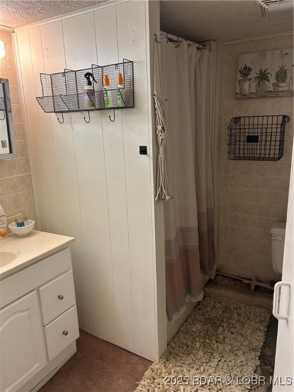 32585 N Ivy Bend Rd, Stover, MO 65078 - full bath with tile walls, vanity, a shower with shower curtain, and toilet