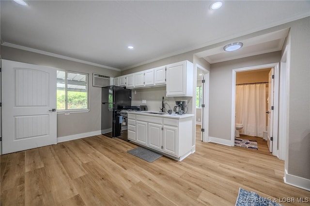 29 Vine St, Edwards, MO 65326 - kitchen featuring range with gas cooktop, white cabinetry, light wood-style floors, light countertops, and crown molding
