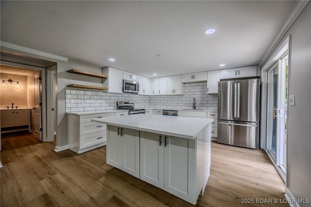 29 Vine St, Edwards, MO 65326 - kitchen with stainless steel appliances, open shelves, white cabinetry, backsplash, and recessed lighting