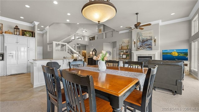 15 Pointe Ct, Lake Ozark, MO 65049 - dining area with ceiling fan, crown molding, recessed lighting, a glass covered fireplace, and a towering ceiling