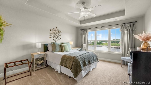 15 Pointe Ct, Lake Ozark, MO 65049 - bedroom with a tray ceiling, baseboards, light carpet, and a ceiling fan