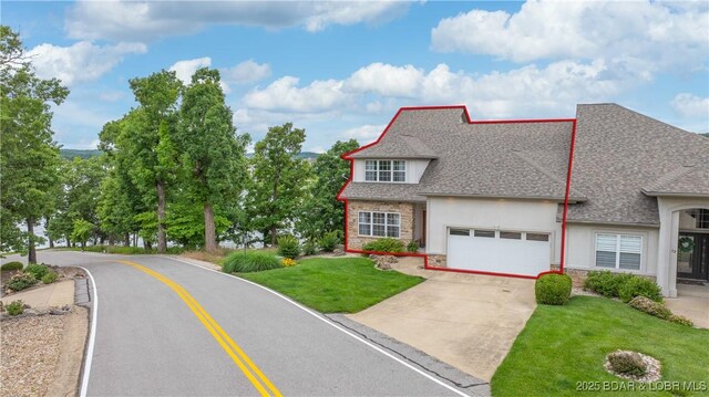 15 Pointe Ct, Lake Ozark, MO 65049 - view of front facade with stucco siding, driveway, stone siding, roof with shingles, and a front lawn