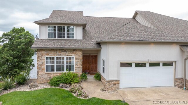 15 Pointe Ct, Lake Ozark, MO 65049 - view of front of home featuring stone siding, roof with shingles, an attached garage, concrete driveway, and stucco siding