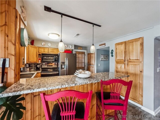 590 Jupiter Rd, Camdenton, MO 65020 - kitchen featuring stainless steel appliances, a breakfast bar area, light stone counters, brown cabinetry, and hanging light fixtures