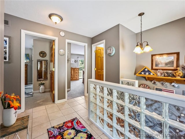 590 Jupiter Rd, Camdenton, MO 65020 - hallway featuring light carpet, a chandelier, and light tile patterned floors