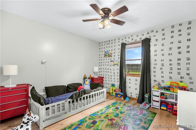 180 Skylark Ln, Linn Creek, MO 65052 - bedroom featuring wood finished floors, a textured ceiling, and a ceiling fan