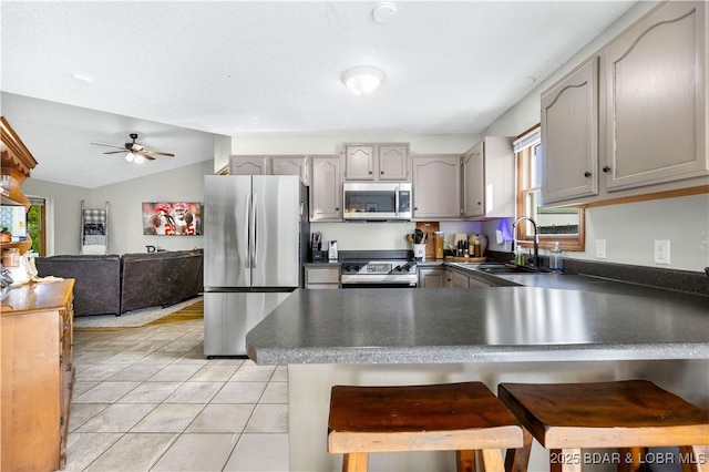 180 Skylark Ln, Linn Creek, MO 65052 - kitchen with appliances with stainless steel finishes, dark countertops, a peninsula, ceiling fan, and light tile patterned floors