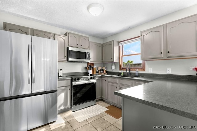 180 Skylark Ln, Linn Creek, MO 65052 - kitchen featuring stainless steel appliances, dark countertops, gray cabinets, and light tile patterned flooring
