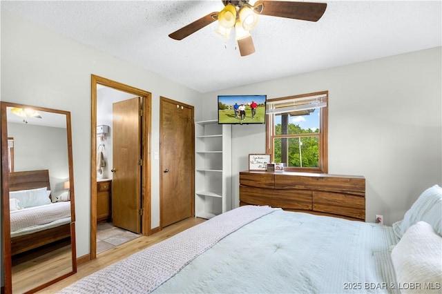 180 Skylark Ln, Linn Creek, MO 65052 - bedroom with light wood-type flooring, lofted ceiling, a textured ceiling, multiple closets, and ceiling fan