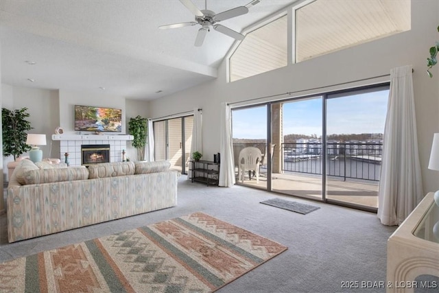 106 Falls Pointe Dr Unit 8C, Lake Ozark, MO 65049 - carpeted living room with ceiling fan, a tile fireplace, and high vaulted ceiling