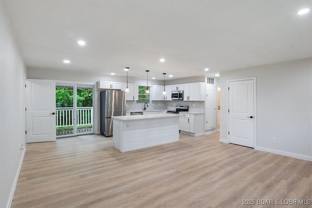 13 Leisure Rd, Eldon, MO 65026 - kitchen with appliances with stainless steel finishes, recessed lighting, white cabinets, light wood finished floors, and a center island