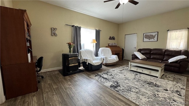 18997 Mystical Ln, Versailles, MO 65084 - living room with healthy amount of natural light, a ceiling fan, dark wood-type flooring, and a wood stove