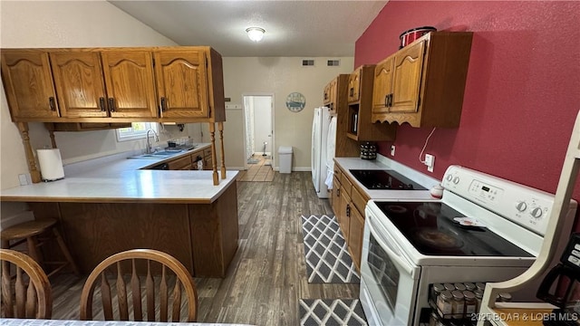 18997 Mystical Ln, Versailles, MO 65084 - kitchen featuring white appliances, light countertops, brown cabinetry, and dark wood finished floors